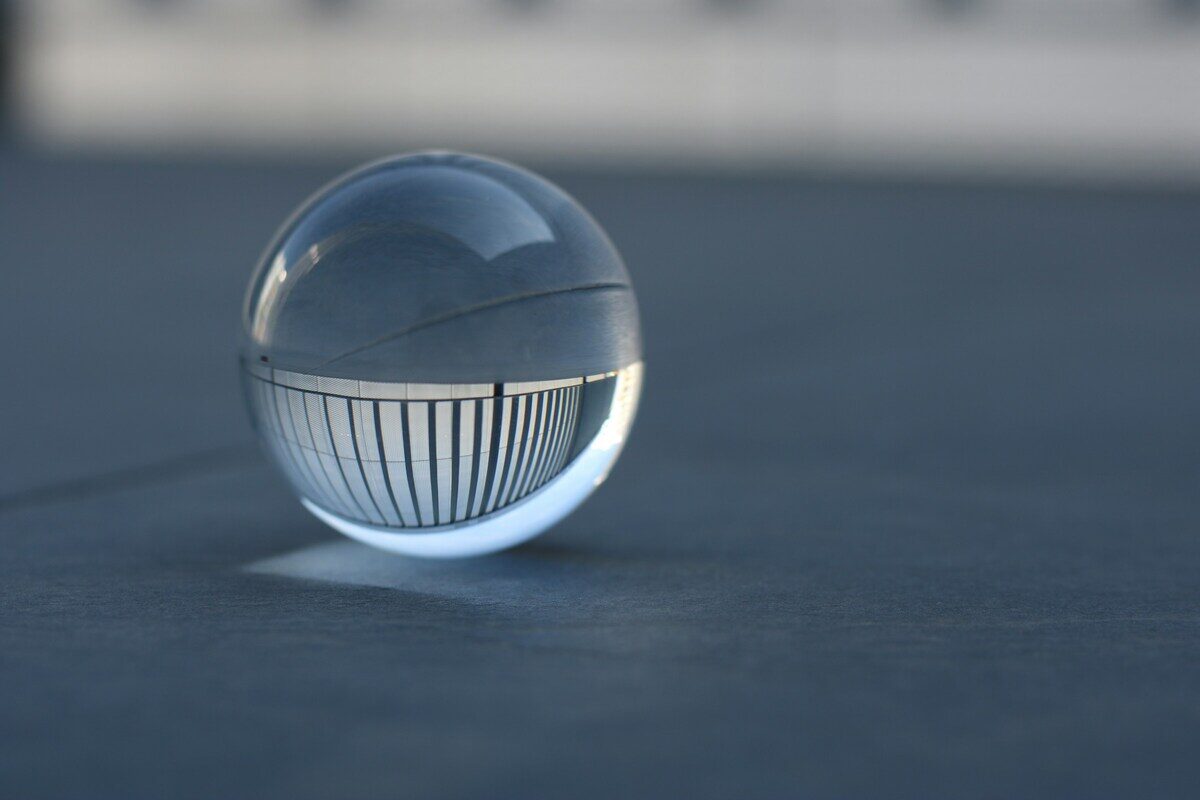 A clear glass sphere resting on a surface, bending the lines behind it